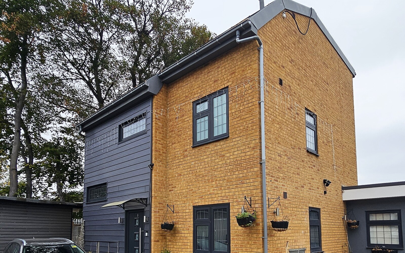 The new-build house in Croydon, seen from the driveway, with its brick and dark-clad two-storey elevation